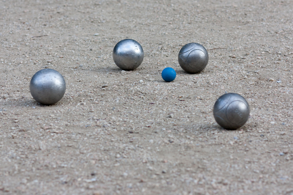 Billede med 4 petanque kugler på grus
